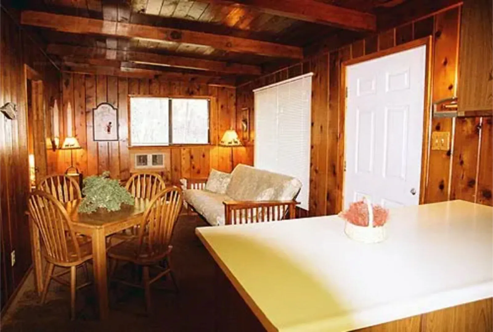 Cabin 2 bedroom at Silverthorn Resort — wood-beam ceiling, bunk bed with bear-print quilts and a double bed in a two-bedroom Shasta Lake family cabin