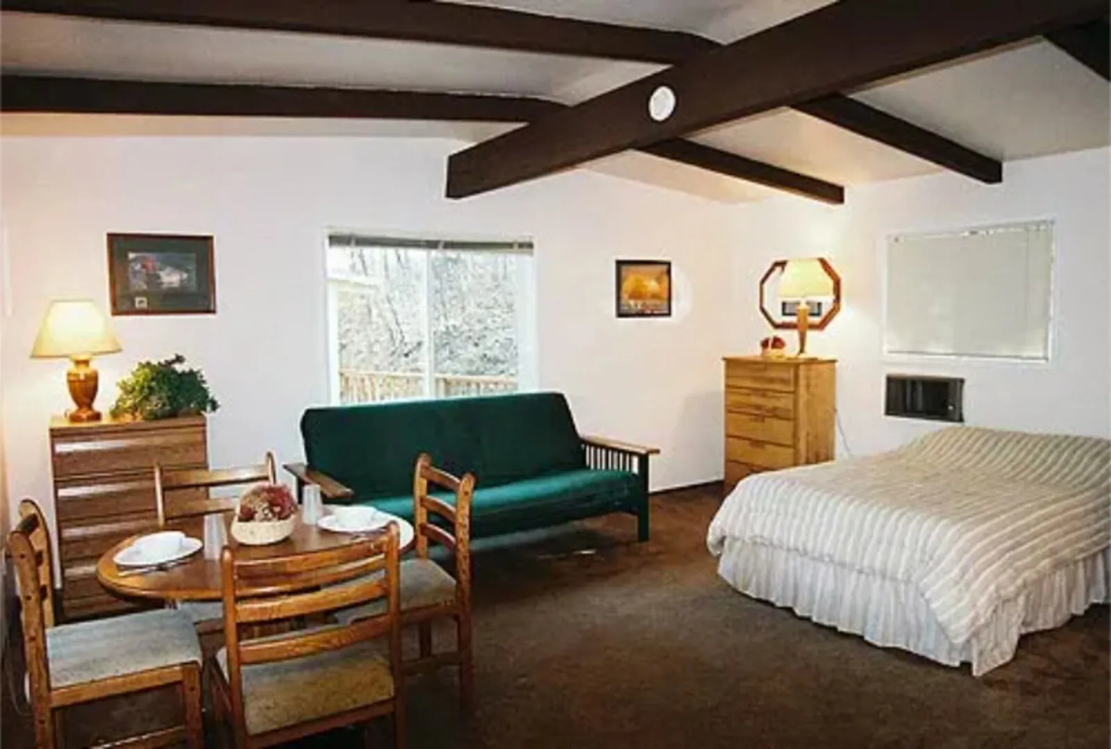 Cabin 5 studio interior at Silverthorn Resort — bright open layout with double bed, futon sofa and dining table in a Shasta Lake lakeside studio cabin