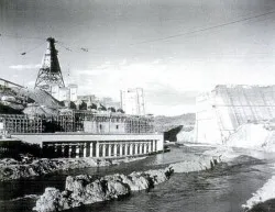 Shasta Dam spillway under construction with cableway towers in the background