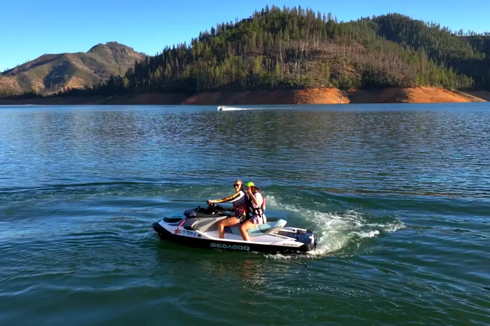 Close-up of SeaDoo GTX 130 riders spraying water at sunset on Shasta Lake near Silverthorn
