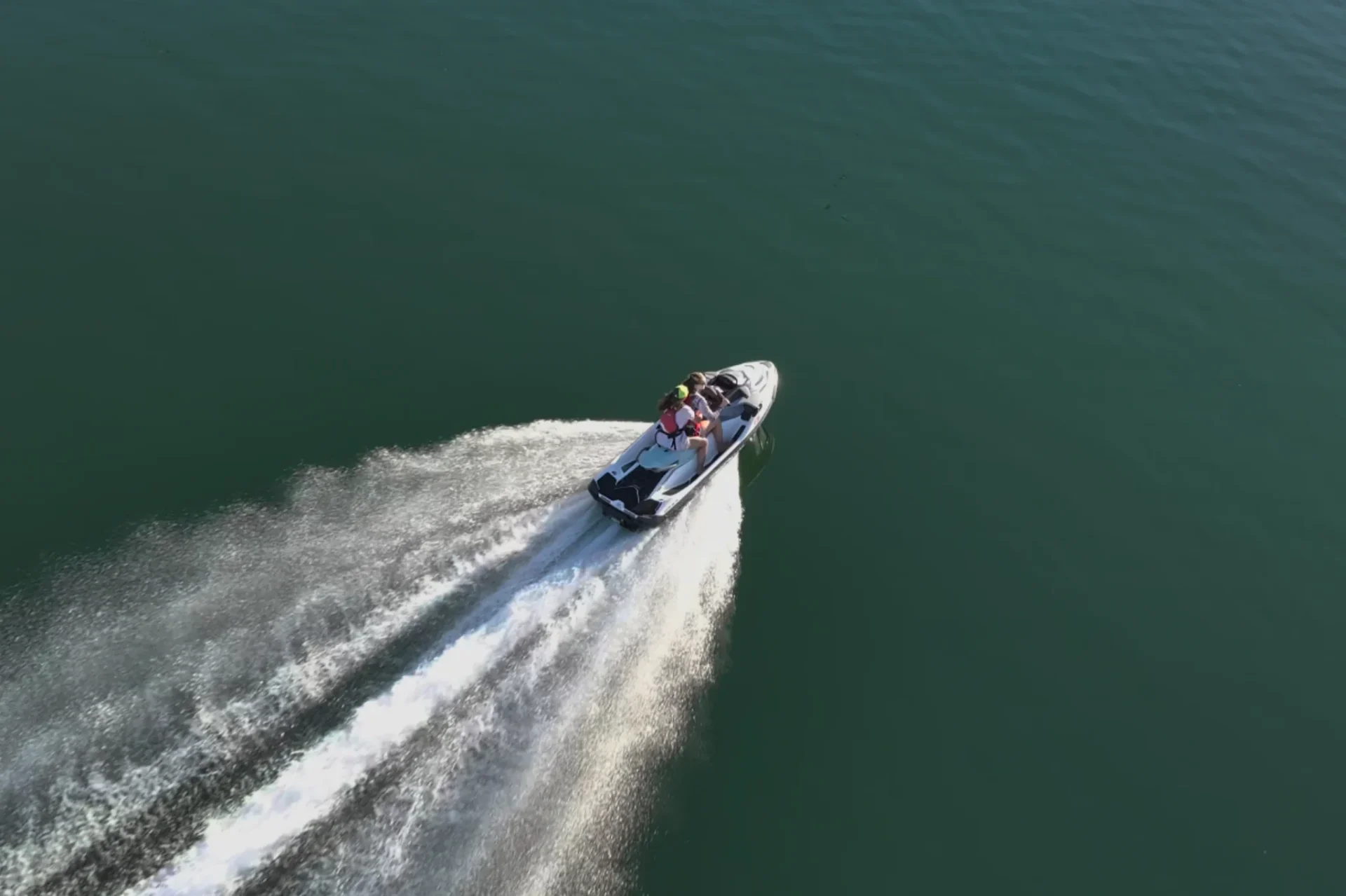 Jet ski rider silhouetted against sunset with Pit River Bridge visible in the background on Shasta Lake