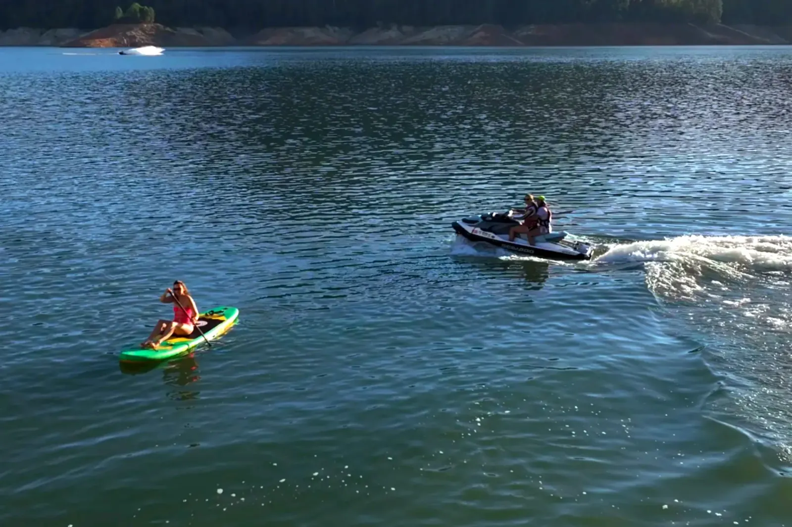 Stand-up paddleboard and SeaDoo jet ski enjoying a summer day together on Shasta Lake