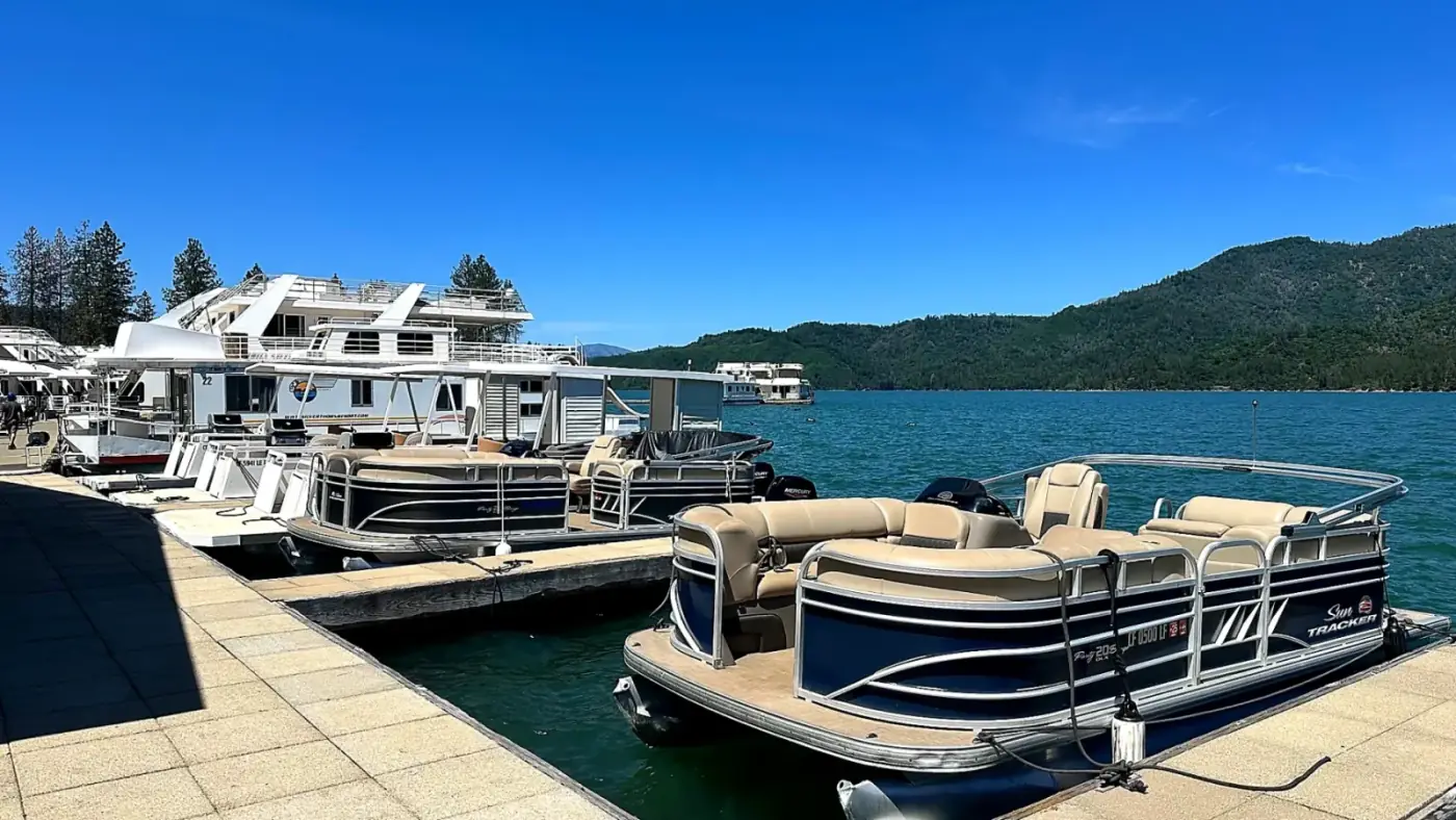 Sun Tracker Pontoons docked at Silverthorn Resort marina with houseboats and Shasta Lake mountains