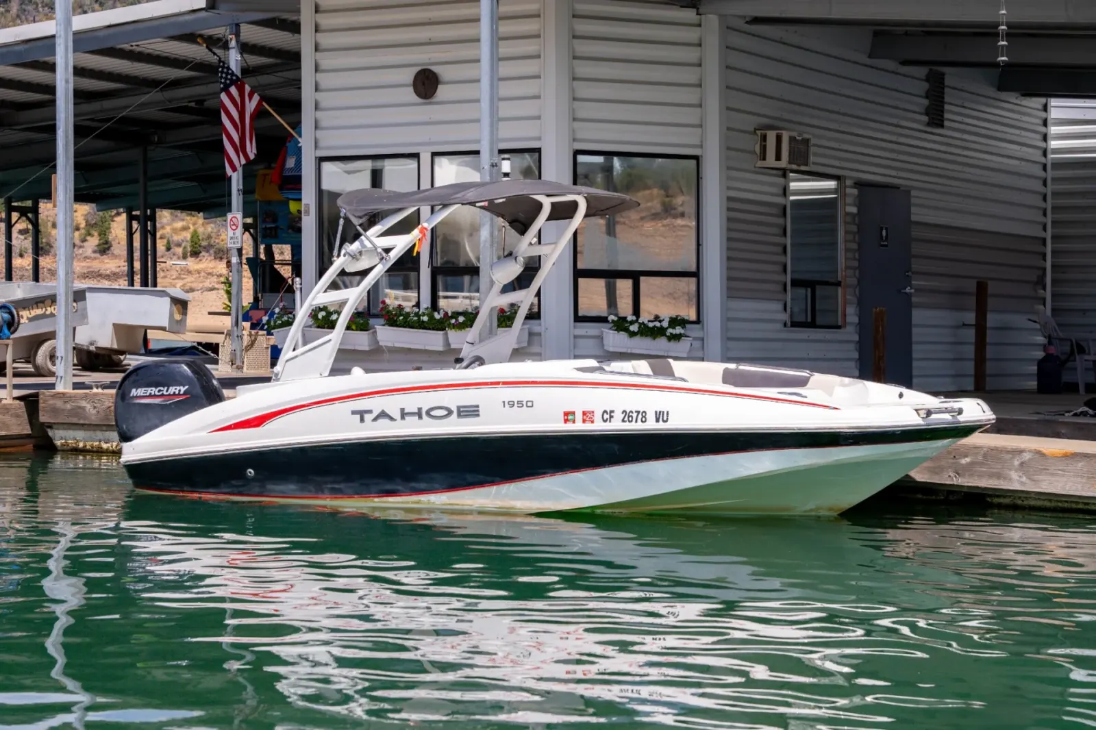 Tahoe Deck Boat 150 port side view at Silverthorn Resort building on Shasta Lake